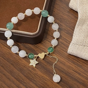 Bracelet élégant en perles blanches et vertes avec breloques cœur et étoile sur bois