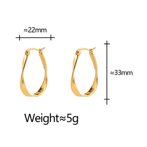Detail view of gold spiral hoop earrings with dimensions 22mm by 33mm and 5g weight