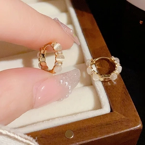Boucles d'oreilles huggies dorées avec pierres œil de chat blanches et zircons fins
