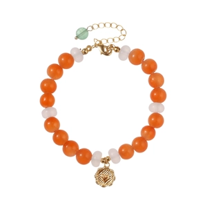 Bracciale fatto a mano con perle arancioni e bianche e ciondolo a cuore dorato su sfondo bianco