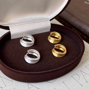Detail of matte brushed geometric round hoop earrings in gold and silver finish