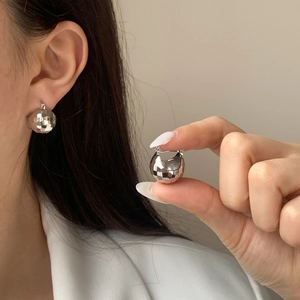 Boucles d'oreilles boules argentées avec design facetté et texture scintillante