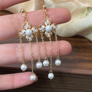 Elegant four-petal flower pearl earrings with long gold tassels and cubic zirconia