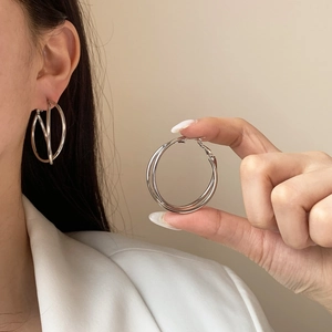Exaggerated silver multi-layered intertwined hoop earrings with a mirror polished finish