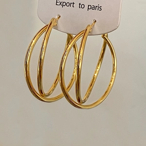 Minimalist double hoop earrings in polished gold finish displayed on a white product card