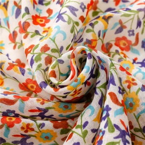 Detailed macro view of soft floral print fabric with vibrant hand-painted patterns