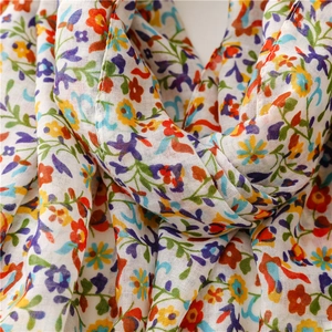 Close-up of lightweight floral scarf showing soft texture and colorful petal patterns