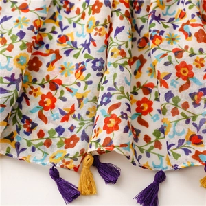 Close-up of floral print scarf with soft texture and colorful fringe tassels details