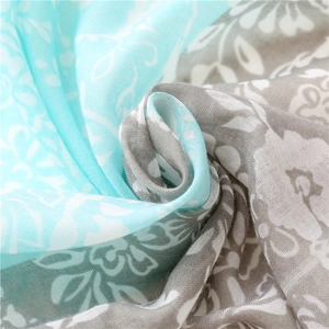 Détail macro d'une écharpe respirante avec imprimé floral bleu au toucher coton et lin