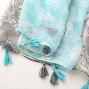 Gros plan sur l'écharpe florale bleu ciel avec texture respirante et bords à franges