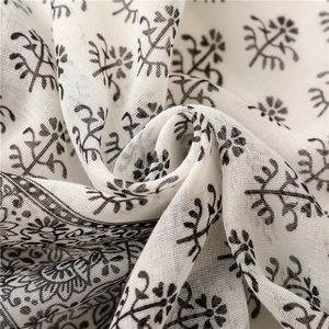 Detail of floral printed fabric showing texture and soft draping of the white scarf