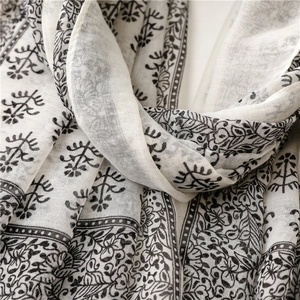 Detailed close-up of vintage black floral print on a lightweight off-white cotton scarf