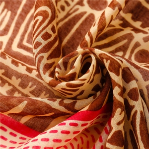 Macro view of bohemian textile texture with artistic brown patterns and red stitching