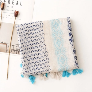 Flat lay of linen scarf with blue geometric patterns, tassels and Cereal magazine