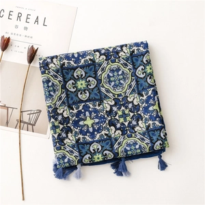 Flat lay of vintage floral scarf with blue tassels and a minimalist lifestyle magazine
