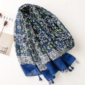 Bohemian floral print scarf in blue and green with tassels on a white background