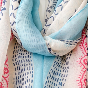 Detailed macro view of floral cotton linen scarf fabric with blue and pink patterns