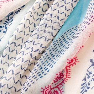 Close-up of lightweight cotton scarf showing delicate blue stripes and floral patterns