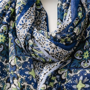 Close-up of lightweight blue and green floral print scarf with intricate paisley patterns