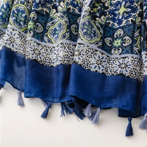 Close-up of floral cotton scarf showing blue tassel fringe and textured fabric weave