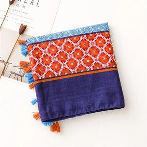Detailed close-up of Bohemian scarf with ethnic geometric patterns and colorful tassels