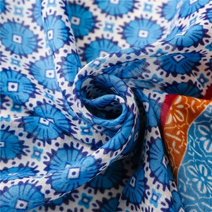 Detail of blue and white floral geometric print scarf fabric with soft draped texture