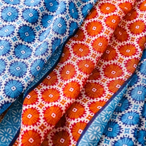 Close-up of blue and orange floral bohemian scarf showing fine texture and hem detail