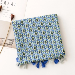 Detail view of the bohemian floral scarf showing blue tassels and geometric vintage patterns