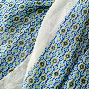 Detailed close-up of lightweight boho floral fabric with blue and green geometric patterns