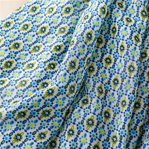 Detail of bohemian floral pattern on light blue chiffon scarf with soft fabric folds