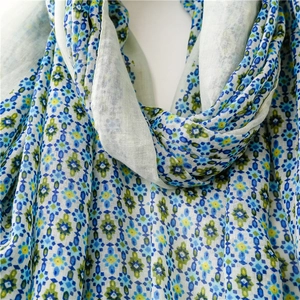 Close-up detail of geometric floral print on lightweight blue and green scarf fabric