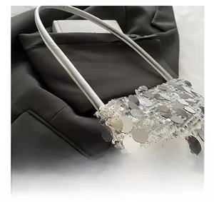 Detail van glanzende zilveren lovertjes en fijne stiksels op een luxe avondschoudertas