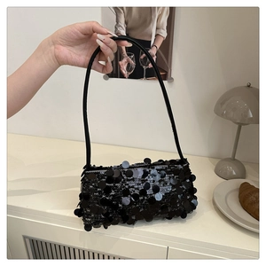 Détail d'un sac porté épaule élégant en paillettes noires avec des sequins réfléchissants