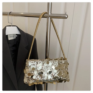 Detail of shimmering gold sequins on a luxury underarm bag for evening gala attire