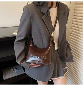 Detail of vintage dark brown semi-circle bag with letter embossing and zipper closure