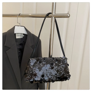 Detailed view of black sequined shoulder bag hanging on a rack for a chic evening look