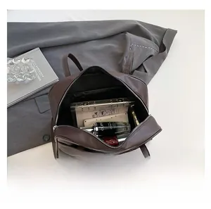 Top view showing spacious interior of dark brown tote bag with cosmetics and notebook
