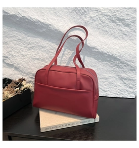 Detail view of burgundy leather shoulder bag showing smooth texture and silver metal zipper
