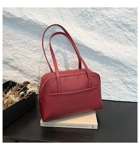Detail of dark red rectangular shoulder bag with side pocket and matte leather texture