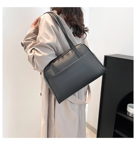 Minimalist black matte leather tote bag shown on shoulder for daily style and size reference