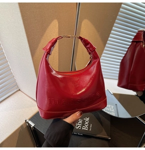 Detail of red crescent bag with maisone embossing and gold metallic hardware