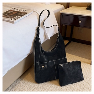 Dettaglio della borsa hobo in pelle scamosciata nera con cuciture a contrasto