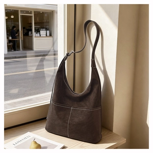 Dettaglio della borsa Hobo in pelle scamosciata marrone scuro con cuciture bianche