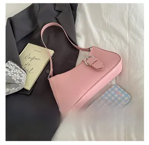 Detailed comparison of pink baguette bag size next to a smartphone in a chic setting