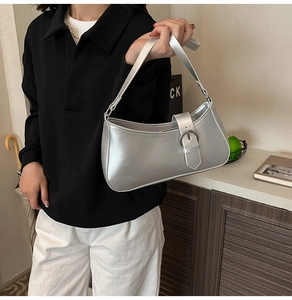 Silver metallic underarm bag featuring a minimalist design with a sleek metal buckle detail