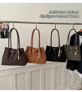 Dettaglio di quattro grandi borse tote in camoscio marrone, nero e verde con nappine a perle