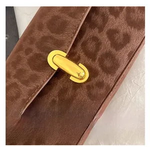 Gros plan du fermoir doré en métal sur le sac à main marron avec motif léopard texturé