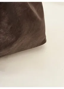 Vista macro di una borsa tote tortora scuro con trama in pelle naturale e cuciture fini