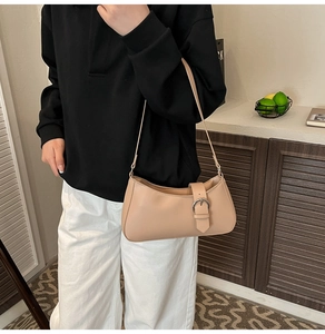 Detail of minimalist apricot underarm bag with silver buckle and smooth faux leather finish