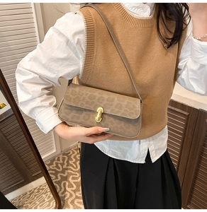 Détail du sac sous le bras à motif léopard avec boucle en métal doré sur cuir suédé